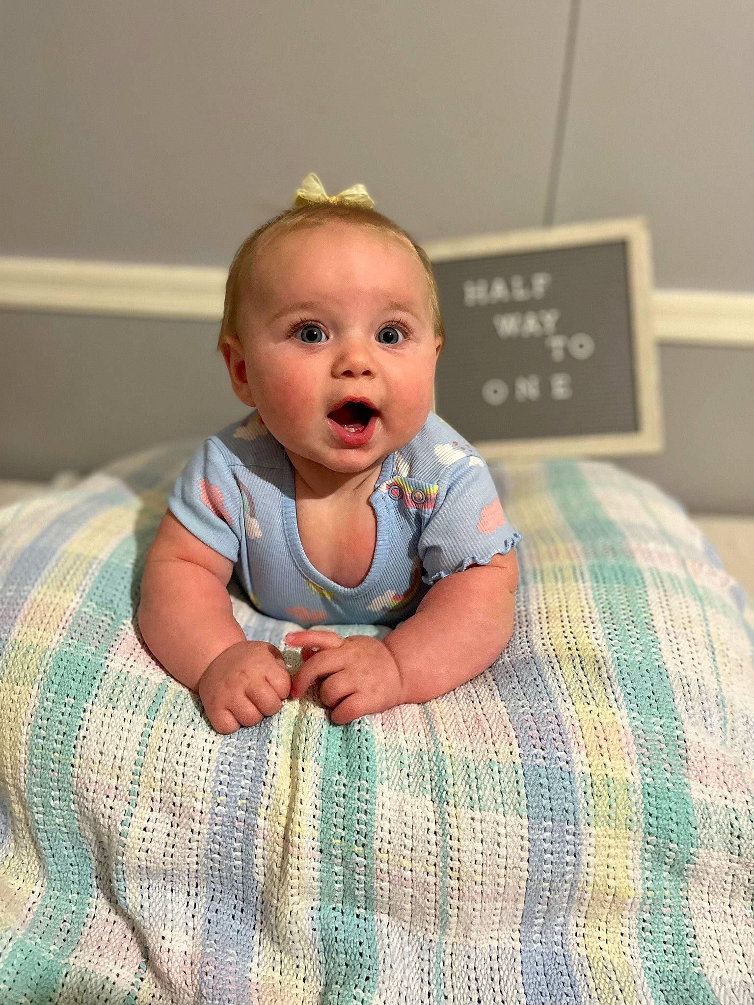 Brinley joined the competition — help win amazing prizes! baby, baby_toddler_clothing, child, comfort, eye, floor, flooring, fun, happy, linens, pattern, person, plaid, room, sitting, skin, sleeve, smile, surprise, tartan