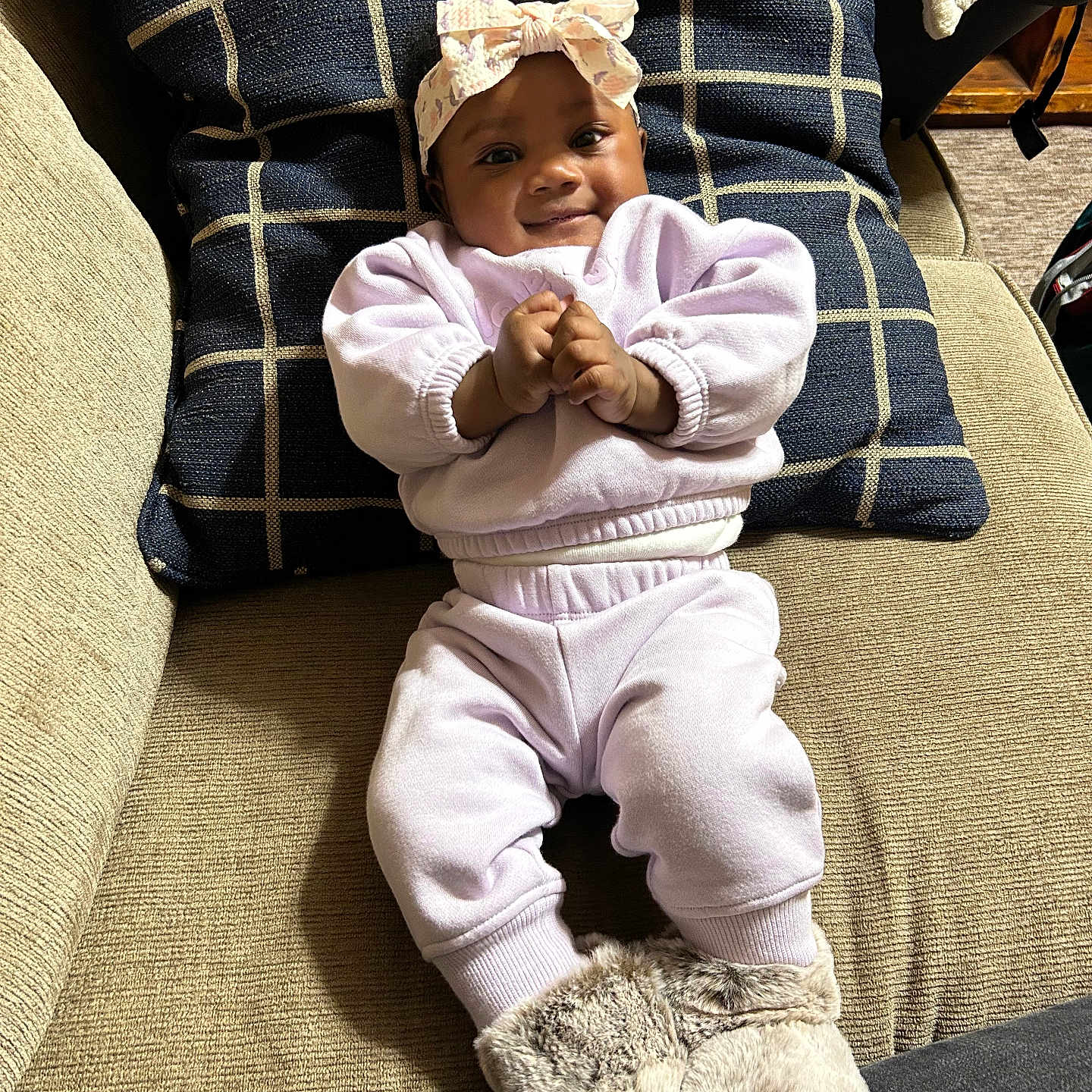 Avaia is registered to the contest to win money with this photo: apparel, baby, boots, child, clothing, comfortable, couch, cozy, cute, fabric, face, furniture, headband, indoors, infant, person, pillow, portrait, seated, smile