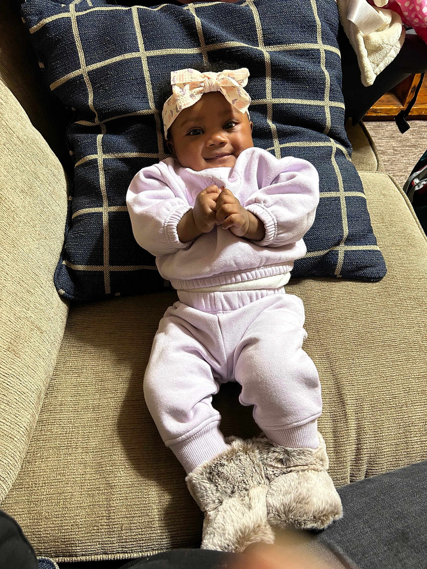 Avaia is registered to the contest to win money with this photo: baby, infant, child, couch, pillow, clothing, boots, headband, smile, face, indoors, cozy, fabric, furniture, person, apparel, comfortable, seated, cute, portrait