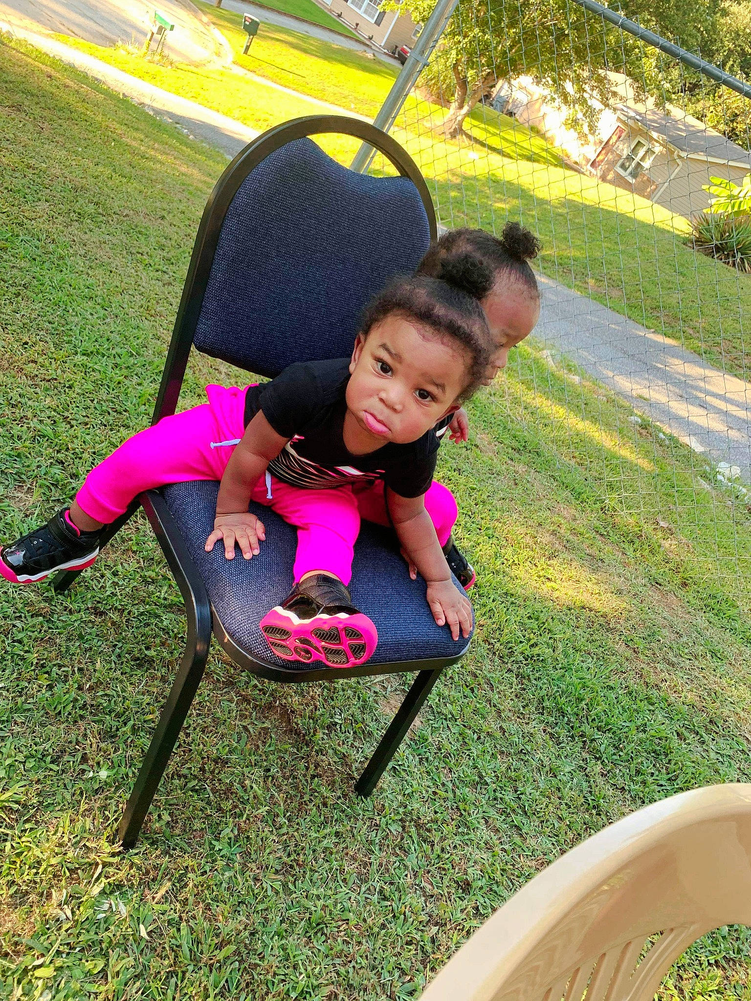 Kevon is registered to the contest to win money with this photo: backyard, chair, child, garden, grass, happy, lawn, leisure, person, pink, plant, play, playground, recreation, sitting, smile, summer, toddler, tree, vacation