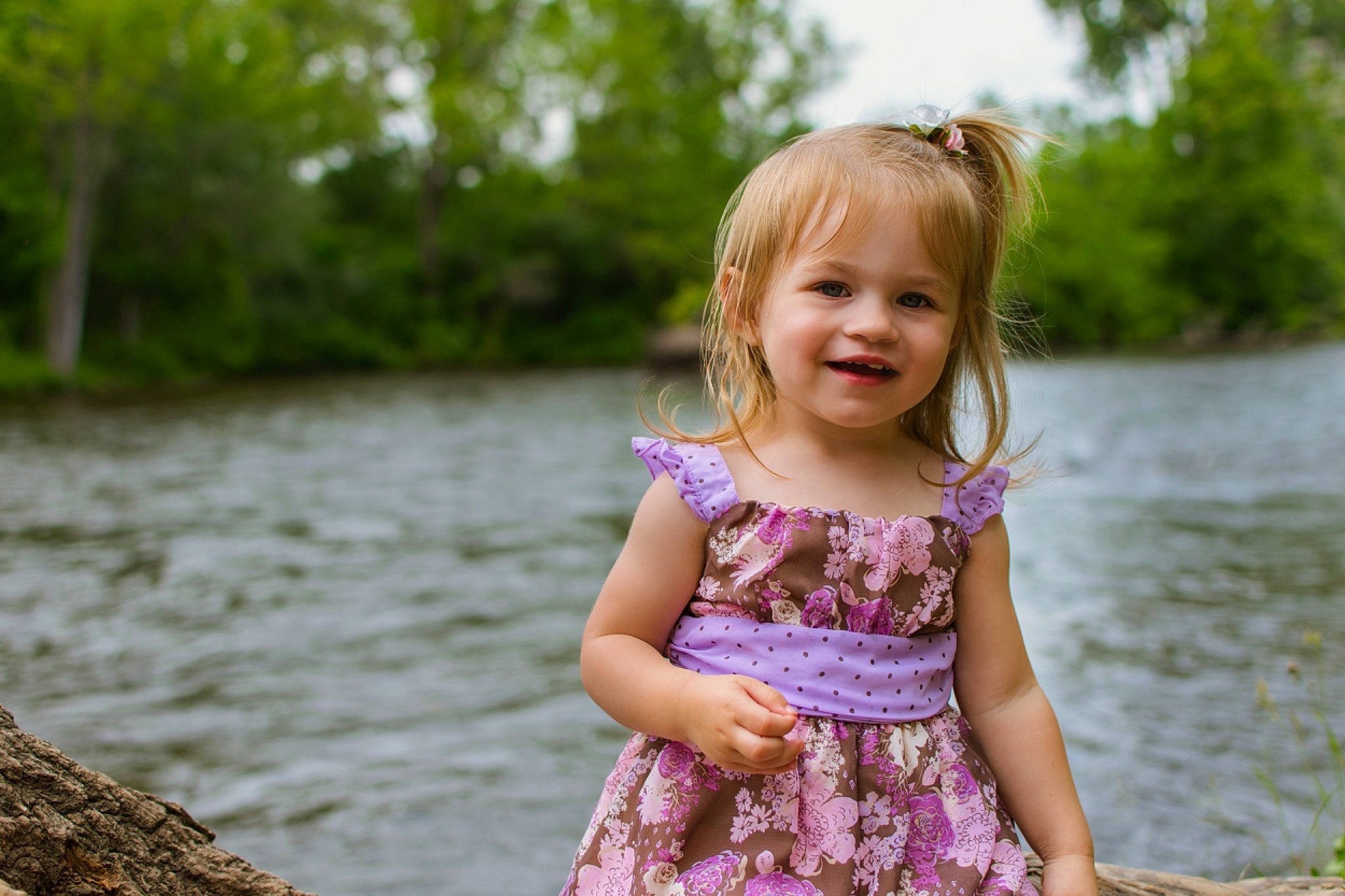 Lillyonna is registered to the contest to win money with this photo: bank, blond, child, child_model, dress, eye, grass, joy, lake, people, people_in_nature, person, photography, pink, plant, river, smile, summer, toddler, tree