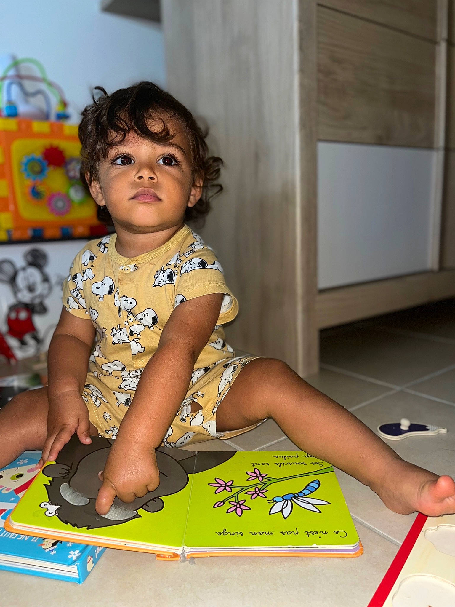 Royn participe au concours pour gagner de l'argent avec cette photo : baby, baby_playing_with_toys, baby_toddler_clothing, child, door, dress, facial_expression, floor, flooring, fun, happy, human_leg, leisure, person, play, room, sitting, standing, thigh, toddler
