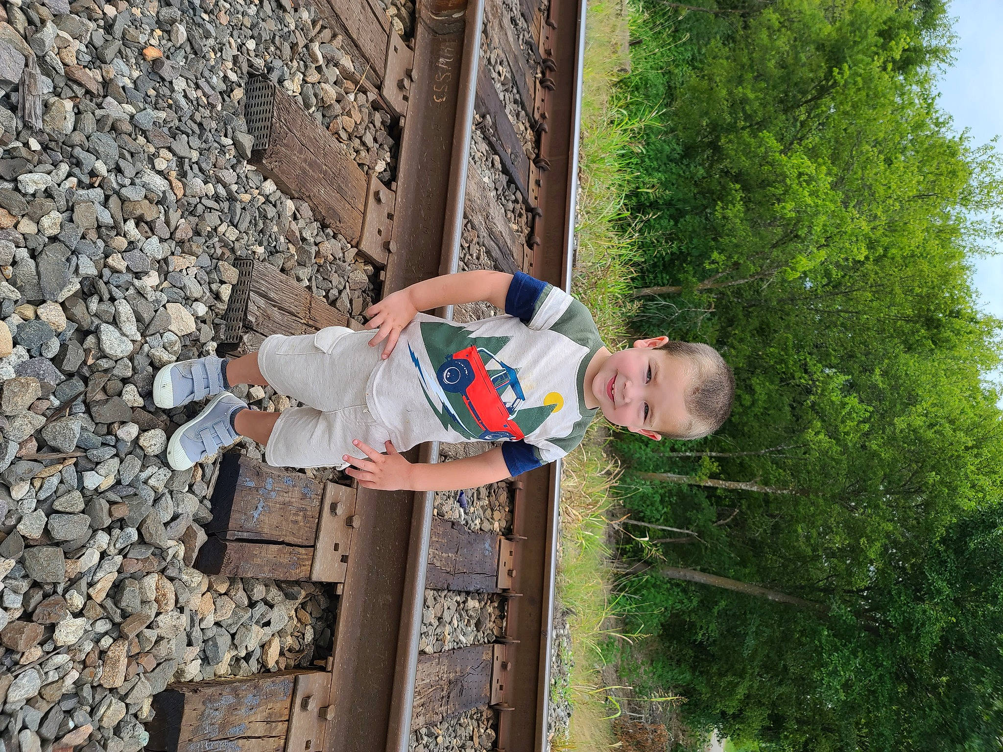 Tripp is registered to the contest to win money with this photo: child, concrete, fun, grass, happy, joy, leisure, outdoor_shoe, people_in_nature, person, plant, recreation, sky, t_shirt, toddler, tree, vacation, walking_shoe, wood