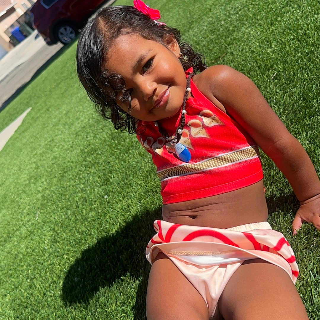 Naima joined the competition — help win amazing prizes! car, child, clothing, face, female, girl, grass, head, lawn, nature, outdoors, park, person, photography, plant, portrait, shorts, summer, swimwear, yard