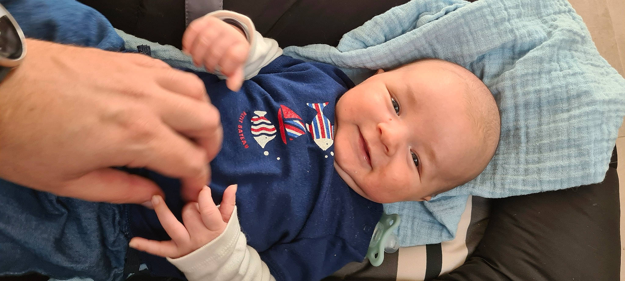 Oscar a rejoint le concours — aidez-le/la à gagner de superbes lots ! baby, baby_toddler_clothing, cheek, child, comfort, elbow, electric_blue, finger, gesture, hand, happy, joy, nail, nose, person, sitting, skin, sleeve, smile, thumb