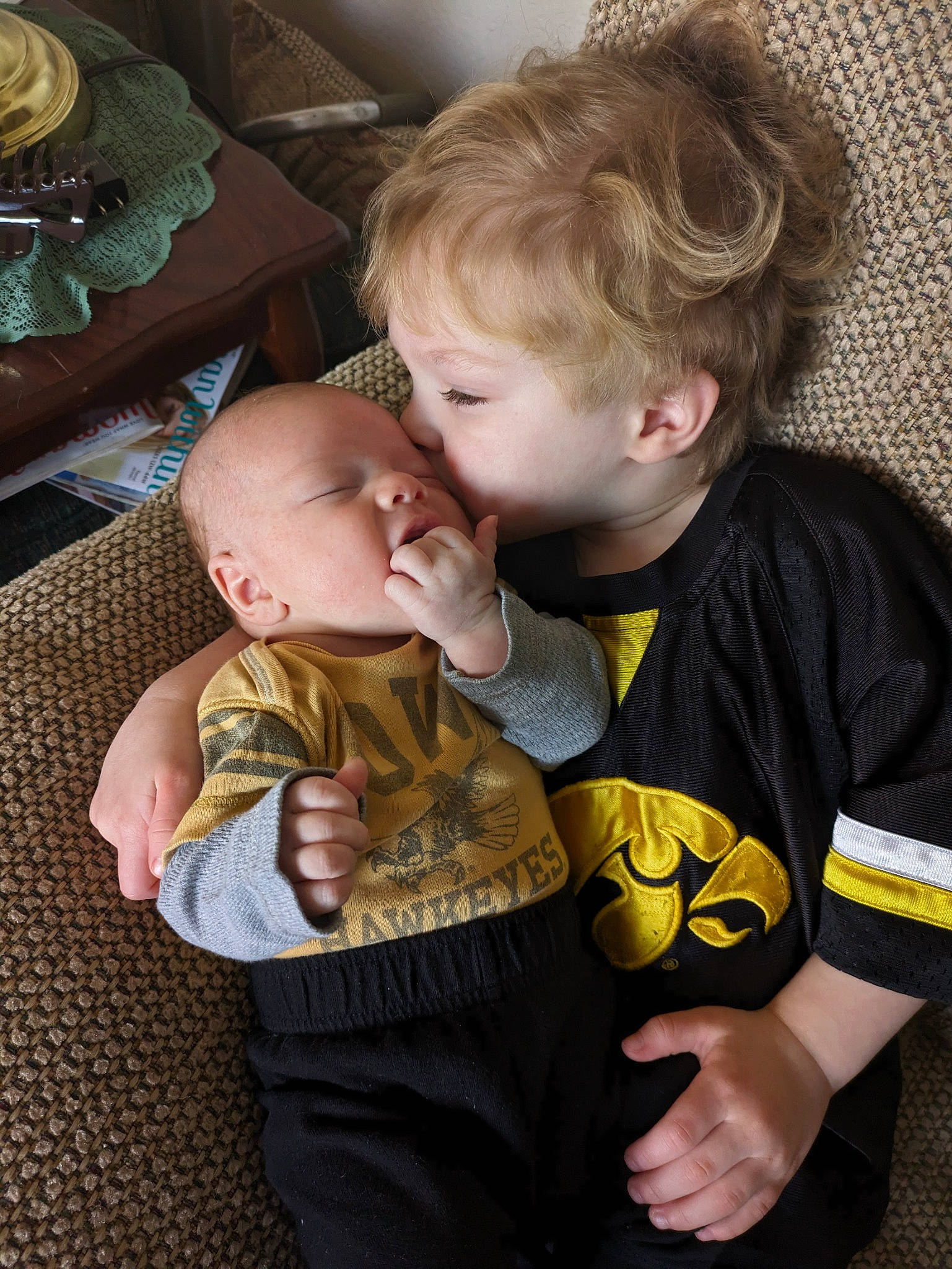 Ragnar And Levi is registered to the contest to win money with this photo: arm, baby, baby_toddler_clothing, chair, cheek, child, comfort, event, fun, gesture, hand, happy, human_body, interaction, mouth, person, sitting, skin, sleeve, t_shirt