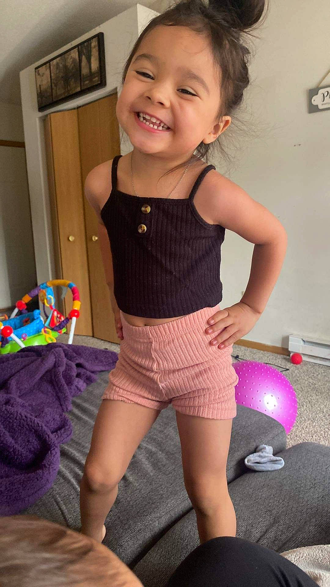 Mariela is registered to the contest to win money with this photo: abdomen, baby_toddler_clothing, face, happy, human_body, joint, joy, knee, leg, neck, person, pink, shoulder, skin, sleeve, smile, sportswear, standing, thigh, toddler
