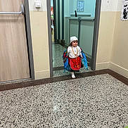 Diana a rejoint le concours — aidez-le/la à gagner de superbes lots ! child, colorful, corridor, curious, decorative, doorway, floor, flooring, footwear, hallway, headwear, indoor, office, person, small_person, smile, standing, traditional_clothing, wall, young_child