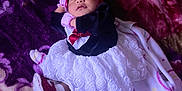 Dulce is registered to the contest to win money with this photo: baby, sleeping, dress, headband, blanket, purple, red, white, infant, cozy, cute, footwear, pattern, soft, child, indoors, resting, peaceful, newborn, clothing