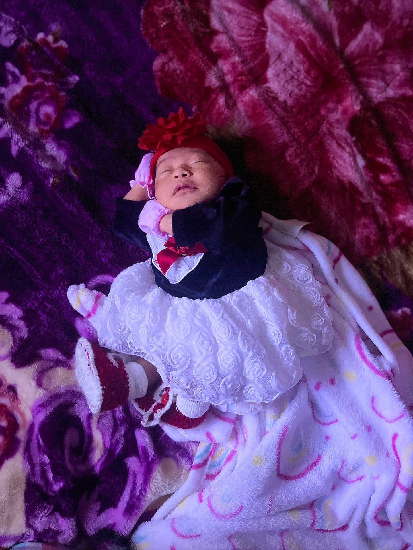 Dulce is registered to the contest to win money with this photo: baby, sleeping, dress, headband, blanket, purple, red, white, infant, cozy, cute, footwear, pattern, soft, child, indoors, resting, peaceful, newborn, clothing