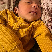 Dulce is registered to the contest to win money with this photo: newborn, baby, sleeping, yellow_clothing, ribbed_fabric, blanket, infant, face, peaceful, closeup, child, portrait, soft_lighting, indoors, resting, cute, small, human, toddler, bed