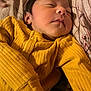 newborn, baby, sleeping, yellow_clothing, ribbed_fabric, blanket, infant, face, peaceful, closeup, child, portrait, soft_lighting, indoors, resting, cute, small, human, toddler, bed