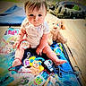 baby, child, infant, sitting, portrait, face, eyes, outdoor, playmat, toys, stuffed_animal, puppy, bubbles, beads, rattle, toy_phone, colorful, playtime, garden, smiling