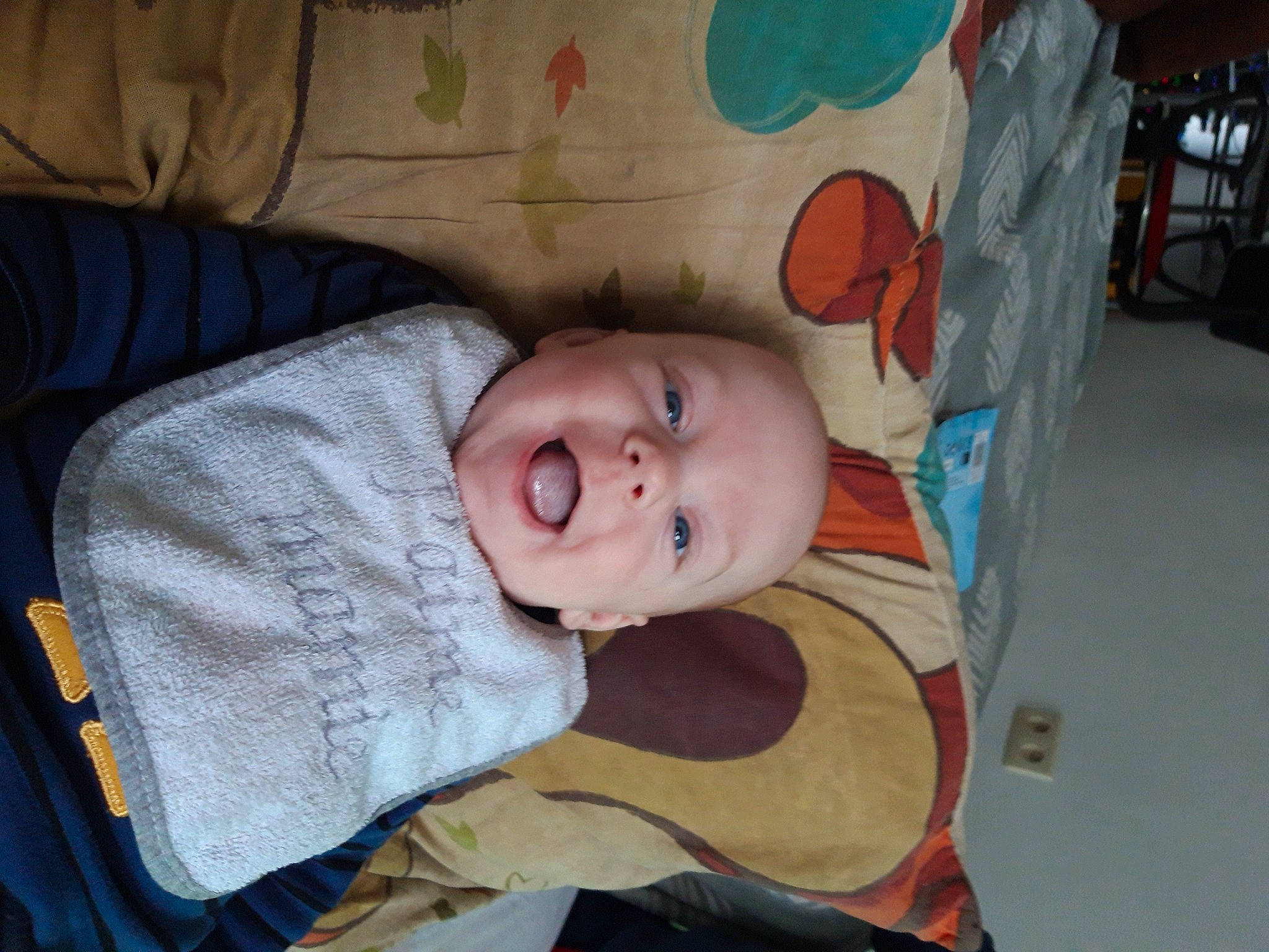 Logan participe au concours pour gagner de l'argent avec cette photo : baby, baby_products, baby_safety, baby_toddler_clothing, bed, cheek, child, chin, comfort, eye, flooring, human_body, infant_bed, iris, linens, nose, person, room, smile, toddler