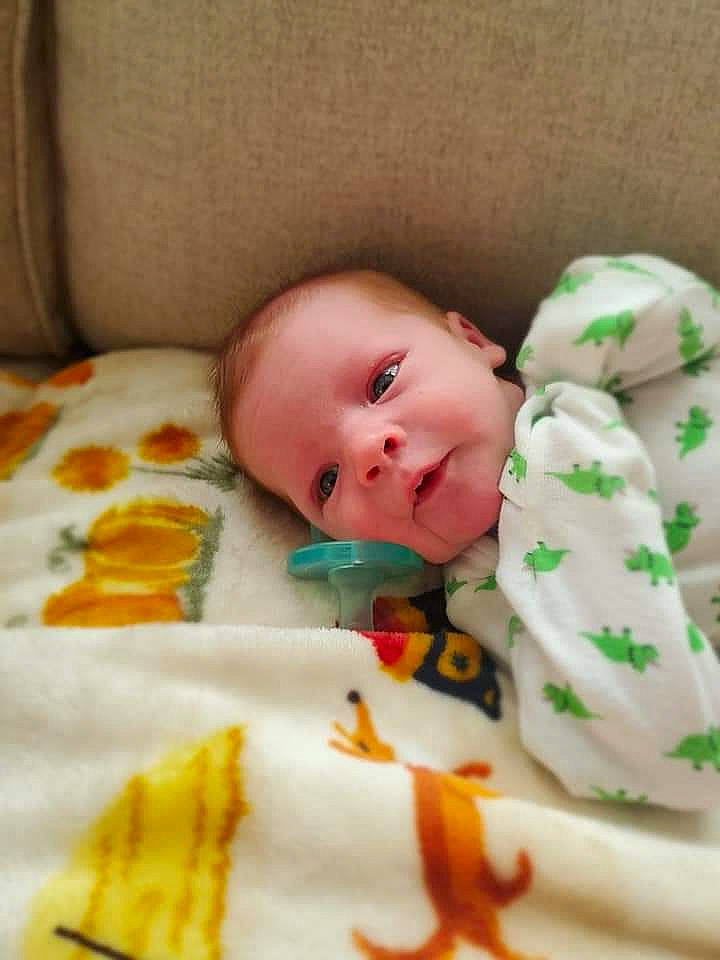 Silas is registered to the contest to win money with this photo: baby, baby_products, baby_sleeping, baby_toddler_clothing, baby_toys, bedding, bedtime, cheek, child, comfort, face, flooring, linens, orange, person, skin, sweetness, textile, toddler, toy