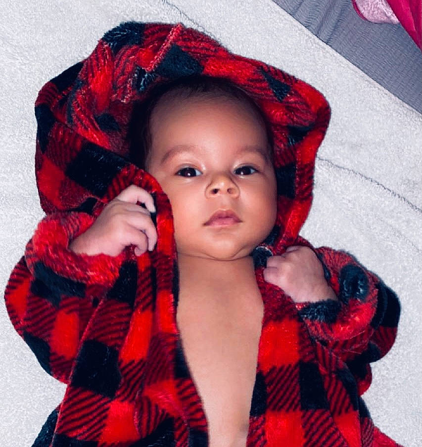 Josiah is registered to the contest to win money with this photo: baby, baby_toddler_clothing, black_hair, cap, cool, dress, eye, eyelash, happy, head, lip, magenta, outerwear, pattern, person, plaid, red, sleeve, tartan, textile