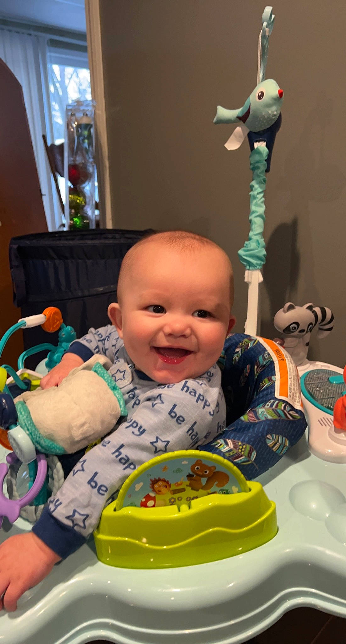 Elliot is registered to the contest to win money with this photo: baby, baby_laughing, baby_products, baby_toddler_clothing, baby_toys, bib, cheek, child, curtain, fun, happy, joy, laugh, person, plant, play, product, room, sitting, smile