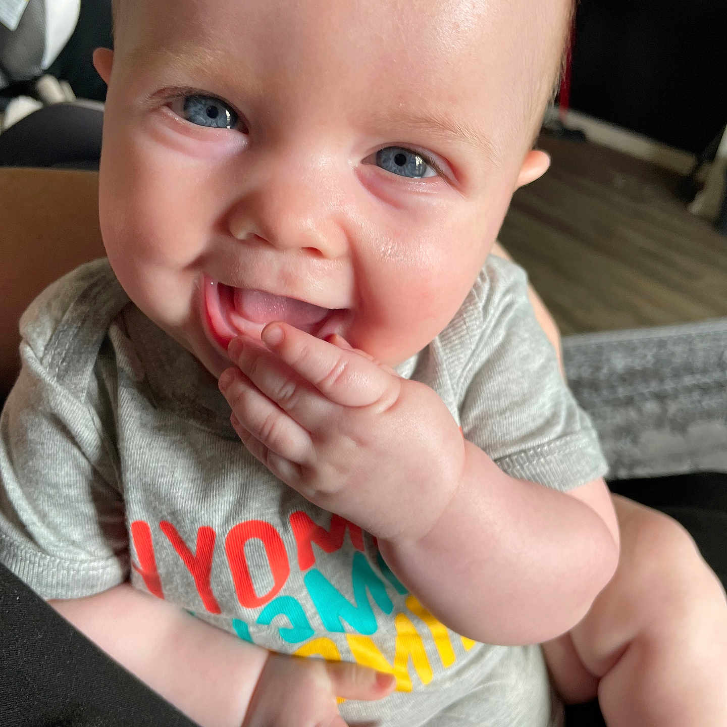 Cory is registered to the contest to win money with this photo: accessories, baby, babylaughing, bodypart, bracelet, clothing, face, finger, hand, happy, head, jewelry, laughing, mouth, person, photography, portrait, sitting, smile, t_shirt