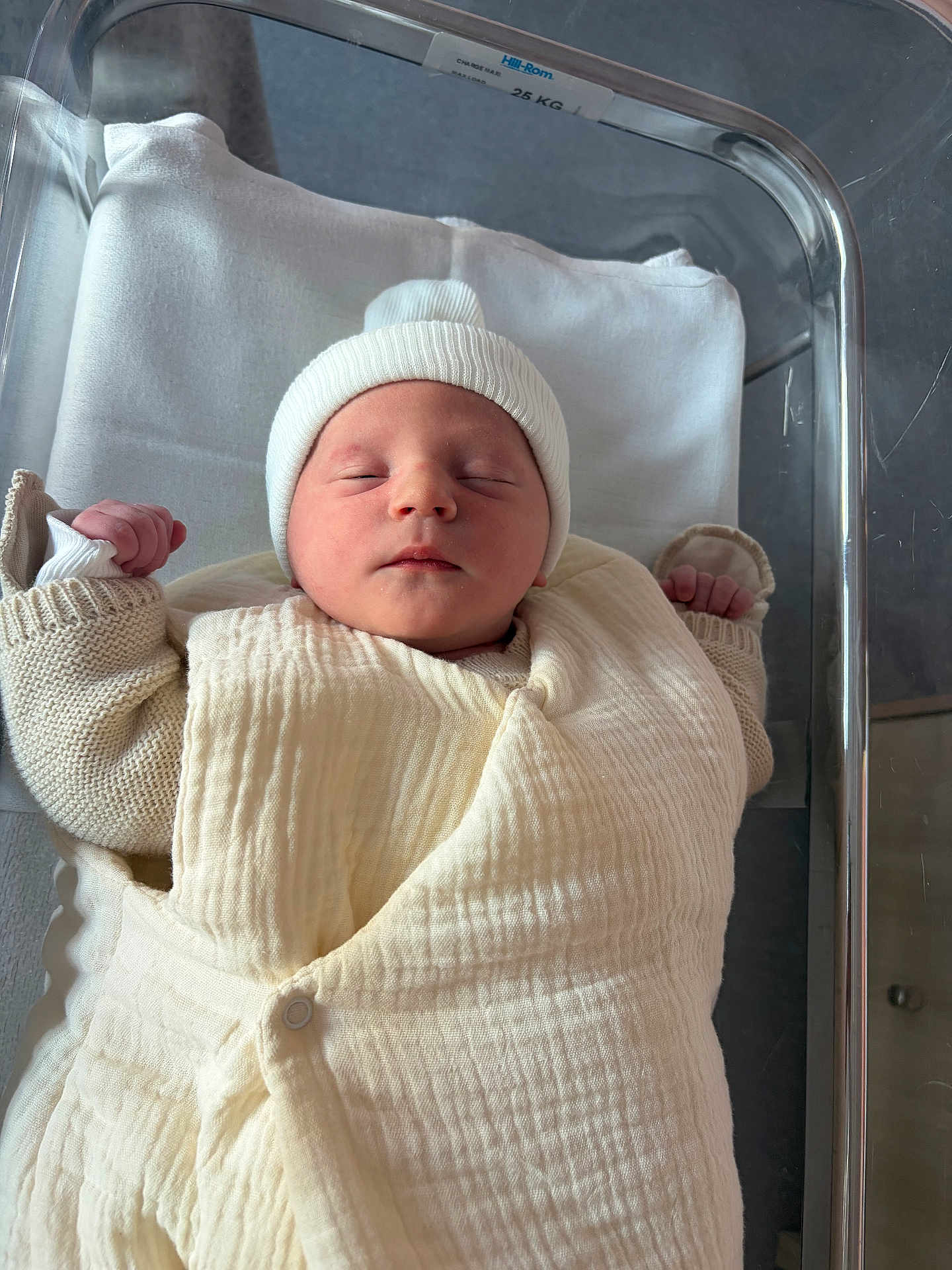 Mylann participe au concours pour gagner de l'argent avec cette photo : newborn, baby, sleeping, swaddled, hospital_bassinet, white_hat, blanket, infant, peaceful, sleep, bed, hospital, soft_light, closeup, child, person, cute, newborn_clothes, baby_clothes, indoors