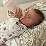 baby, bottle, pacifier, blanket, pillow, onesie, infant, sleeping_area, bed, cute, child, young, skin, hand, face, furniture, indoors, comfort, resting, feeding