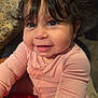 toddler, child, smiling, face, curly_hair, pink_clothing, long_sleeve, happy, portrait, indoor, closeup, baby, cute, person, skin, eyes, nose, mouth, hand, table
