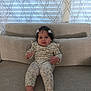 Jackeline joined the competition — help win amazing prizes! baby, child, couch, curly_hair, floral_outfit, hair_clips, indoors, person, portrait, sitting, smile, window, curtains, footwearless, furniture, cozy, light, comfortable, home, cute