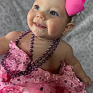Kayla is registered to the contest to win money with this photo: baby, child, pink_dress, headband, bow, beads, smiling, blue_eyes, portrait, cute, infant, closeup, happy, fashion, accessories, soft_blanket, indoors, skin, face, person