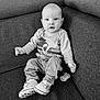 Elyas participe au concours pour gagner de l'argent avec cette photo : baby, child, infant, sitting, couch, clothing, sneakers, pacifier, black_and_white, portrait, indoor, cute, face, expression, person, furniture, long_sleeve, denim_pants, beads, comfort