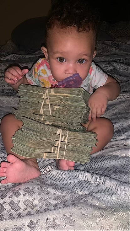 Carsyn is registered to the contest to win money with this photo: baby, baby_toddler_clothing, cheek, child, comfort, eye, flooring, fun, hand, head, linens, mouth, nose, pattern, person, sitting, skin, textile, thumb, toddler