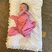 Adelaide is registered to the contest to win money with this photo: baby, infant, blanket, pillow, carpet, pink_blanket, swaddle, lying_down, indoor, portrait, cute, newborn, person, face, head, cozy, ruffles, fabric, floor, home