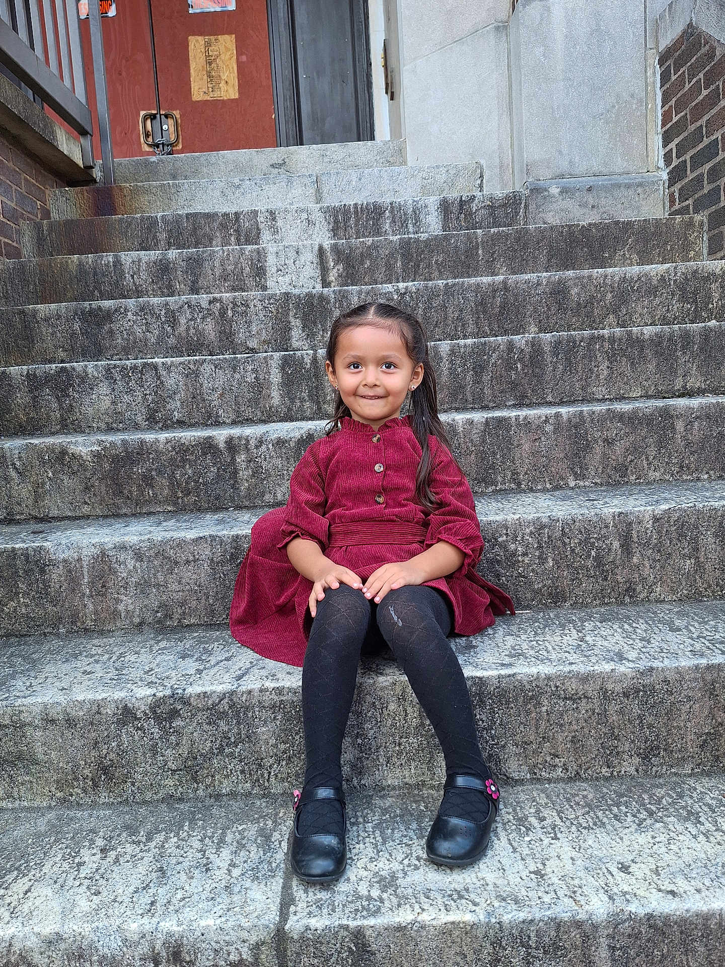 Evelyn is registered to the contest to win money with this photo: architecture, building, child, clothing, coat, face, female, footwear, girl, head, house, housing, jacket, jeans, pants, person, photography, portrait, sitting, staircase
