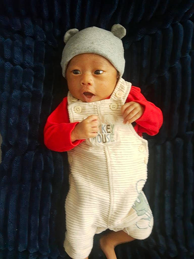 Apolos is registered to the contest to win money with this photo: baby, baby_toddler_clothing, beanie, cap, cheek, child, face, fur, gesture, hat, head, headwear, human_body, human_leg, knit_cap, lip, outerwear, person, sleeve, thumb