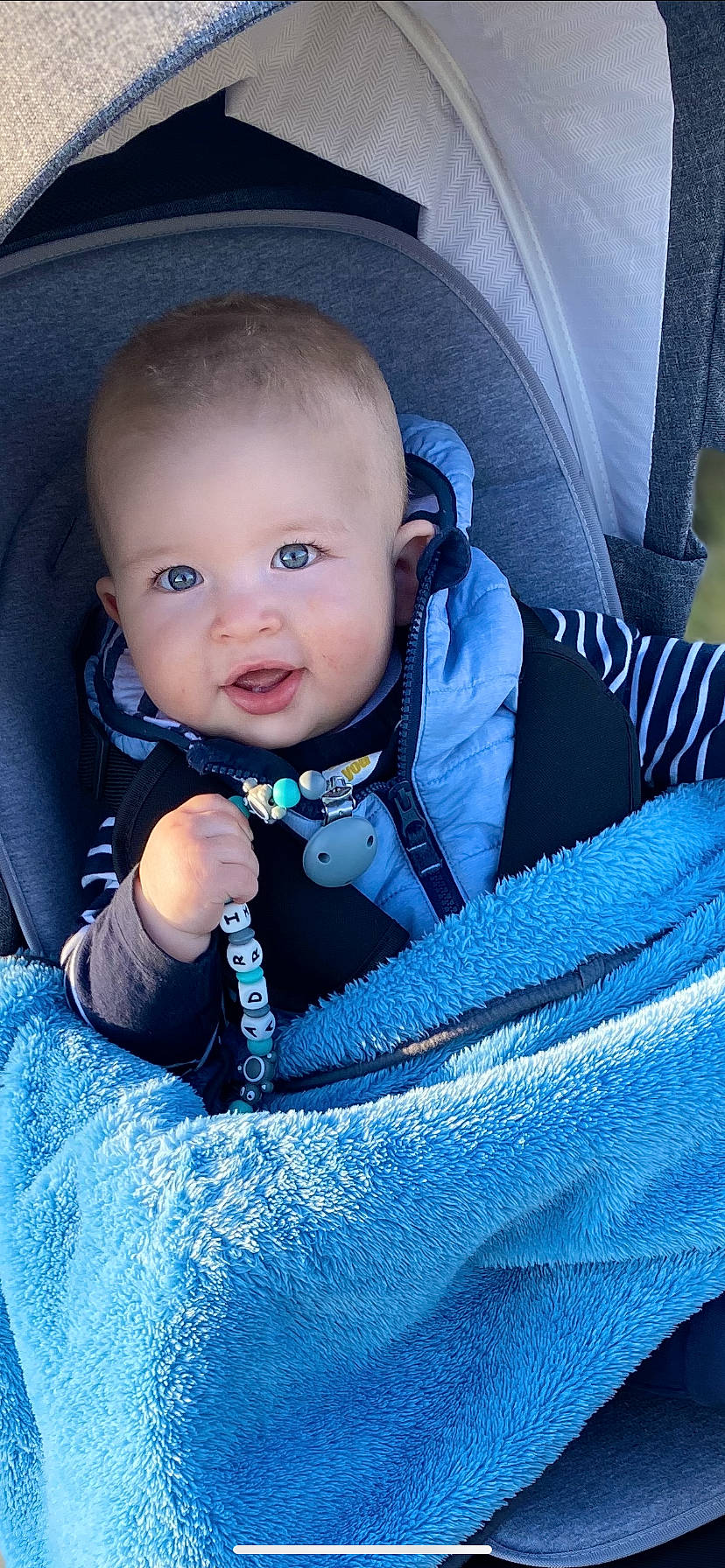 Adrian a rejoint le concours — aidez-le/la à gagner de superbes lots ! baby, baby_carriage, baby_in_car_seat, baby_products, blue, car_seat, cheek, child, eye, iris, person, product, sitting, skin, smile, toddler