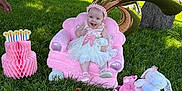 Ashley joined the competition — help win amazing prizes! baby, child, pink_dress, pink_bow, plush_chair, stuffed_animals, balloon, number_six, grass, tree, outdoor, sunny, smiling, happy, headband, park, toy, celebration, birthday, cute