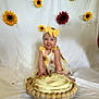 baby, child, cake, birthday, smile, headband, yellow_bow, sunflower, flower, dress, white_background, celebration, happy, sitting, food, sweet, party, cute, decorations, plate
