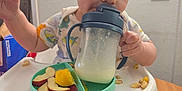 Drew is registered to the contest to win money with this photo: baby, bottle, cutlery, diningtable, dish, eating, face, food, fruit, furniture, head, meal, person, photography, plant, portrait, produce, shaker, spoon, table