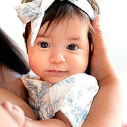 Gemma joined the competition — help win amazing prizes! baby, infant, child, face, headband, bow, eyes, hands, arm, skin, clothing, white, blue, soft_light, portrait, closeup, cute, toddler, person, holding