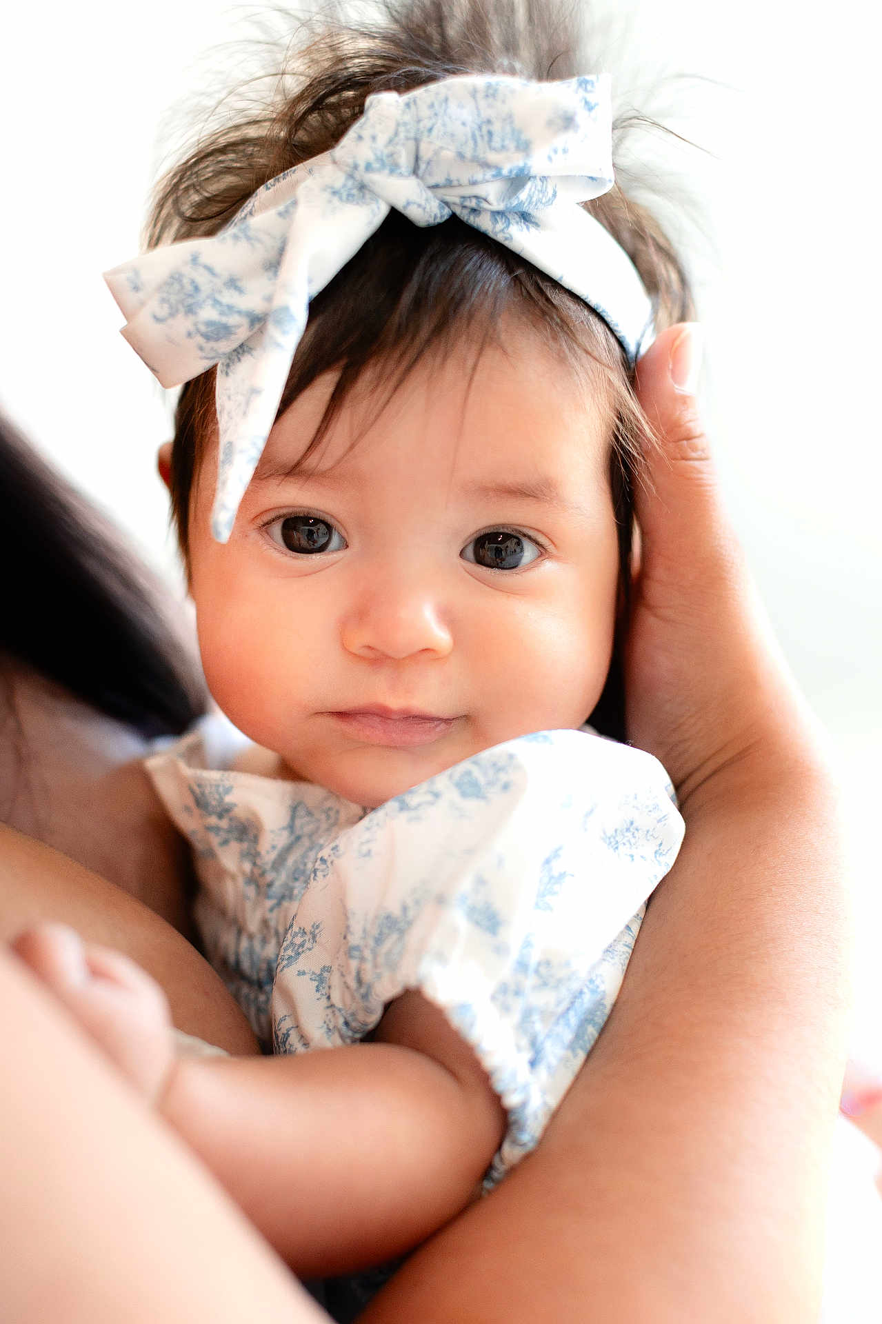 Gemma joined the competition — help win amazing prizes! baby, infant, child, face, headband, bow, eyes, hands, arm, skin, clothing, white, blue, soft_light, portrait, closeup, cute, toddler, person, holding