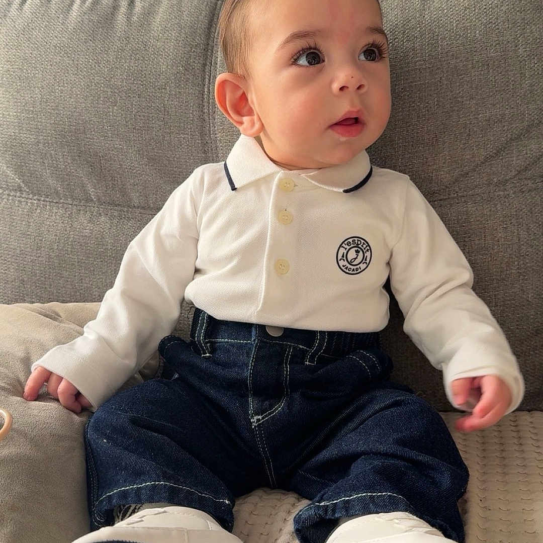 Anas a rejoint le concours — aidez-le/la à gagner de superbes lots ! baby, child, polo_shirt, jeans, shoes, tommy_hilfiger, couch, indoor, portrait, cute, fashion, soft_lighting, sitting, curious, infant, clothing, footwear, face, young_child, home