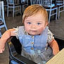 toddler, child, high_chair, blue_eyes, dress, buttoned_clothing, restaurant, chairs, tables, indoor, portrait, person, cute, baby, seated, floor_tiles, table, calm, looking_at_camera, blonde_hair