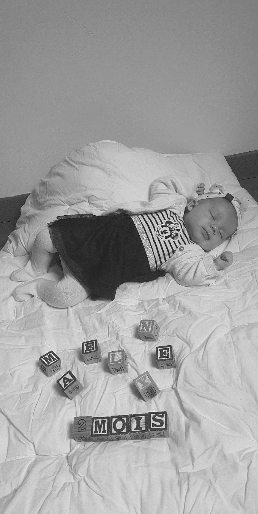 Maëlyne a rejoint le concours — aidez-le/la à gagner de superbes lots ! baby, baby_sleeping, baby_toddler_clothing, bed, bedding, bedtime, black_and_white, comfort, font, grey, human, linens, mammal, monochrome, monochrome_photography, pattern, person, sleeve, style, textile