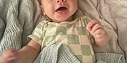 Grayson is registered to the contest to win money with this photo: baby, smiling, blanket, cozy, infant, happy, clothing, face, hand, lying_down, soft_texture, cute, child, indoors, portrait, young, person, skin, head, expression