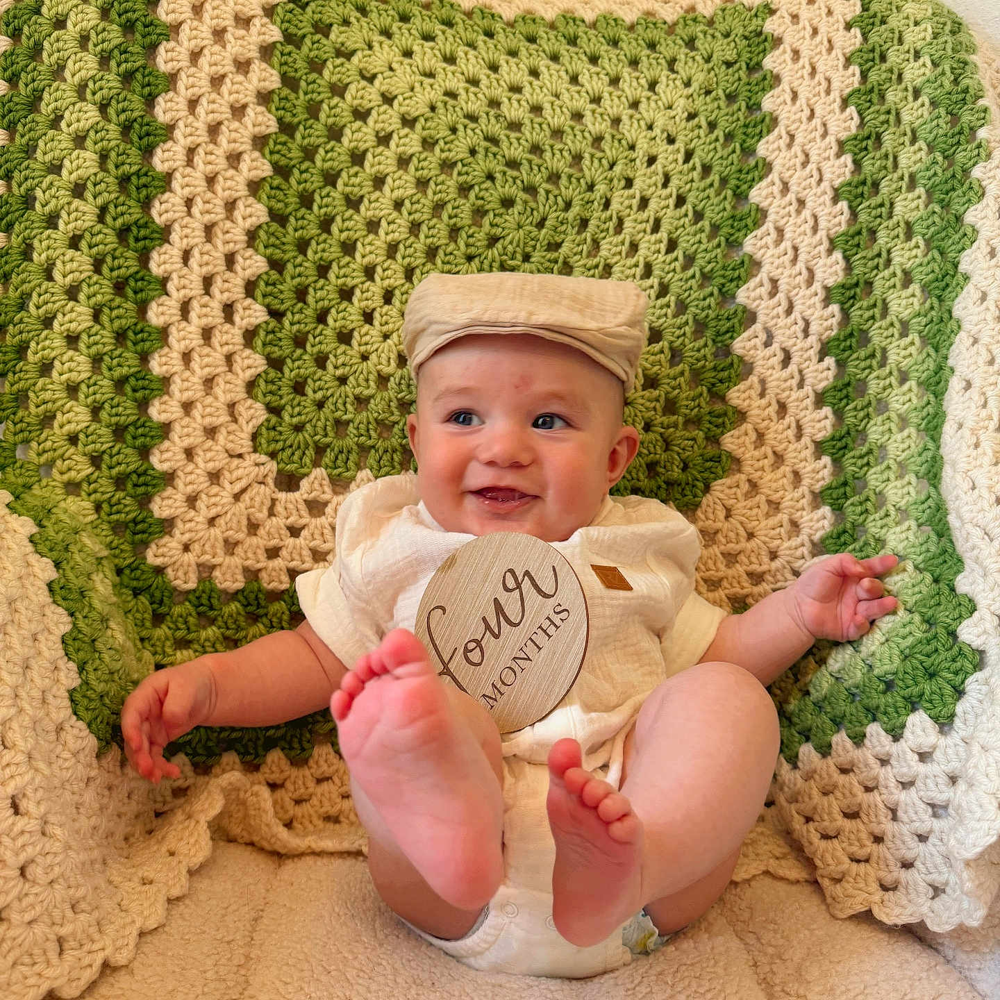 Braxtyn Logan joined the competition — help win amazing prizes! baby, cap, child, comfortable, cozy, cream, crotchet_blanket, cute, cute_baby, feet, four_months, green, happy, indoors, infant, plush_blanket, portrait, sitting, smile, white_outfit