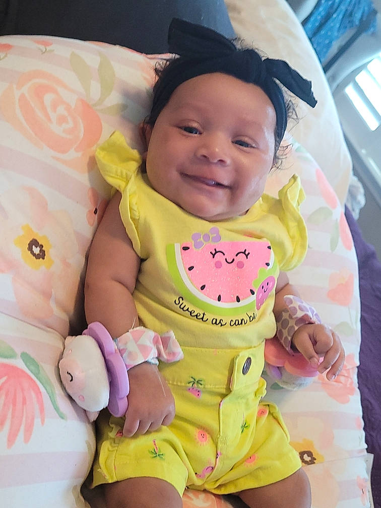 Ka'Lea is registered to the contest to win money with this photo: baby, baby_safety, baby_toddler_clothing, cheek, chin, comfort, eye, finger, gesture, happy, head, headwear, human_body, joy, mouth, person, pink, product, skin, sleeve