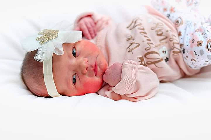 Hadley is registered to the contest to win money with this photo: baby, baby_products, baby_sleeping, baby_toddler_clothing, cap, child, comfort, costume_hat, eyelash, fashion_accessory, hair_accessory, happy, headband, headpiece, headwear, linens, pattern, person, petal, pink
