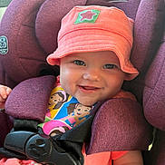 Journey is registered to the contest to win money with this photo: baby, child, car_seat, hat, pink, purple, smiling, straps, safety, seatbelt, cute, infant, happy, portrait, clothing, indoors, face, person, closeup, seat