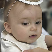 Andrea a rejoint le concours — aidez-le/la à gagner de superbes lots ! adult_hand, baby, celebration, child, closeup, costume, curious, face, focus, gentle, headwear, indoor, infant, number_one, party_hat, person, portrait, skin, soft_lighting, white_clothing