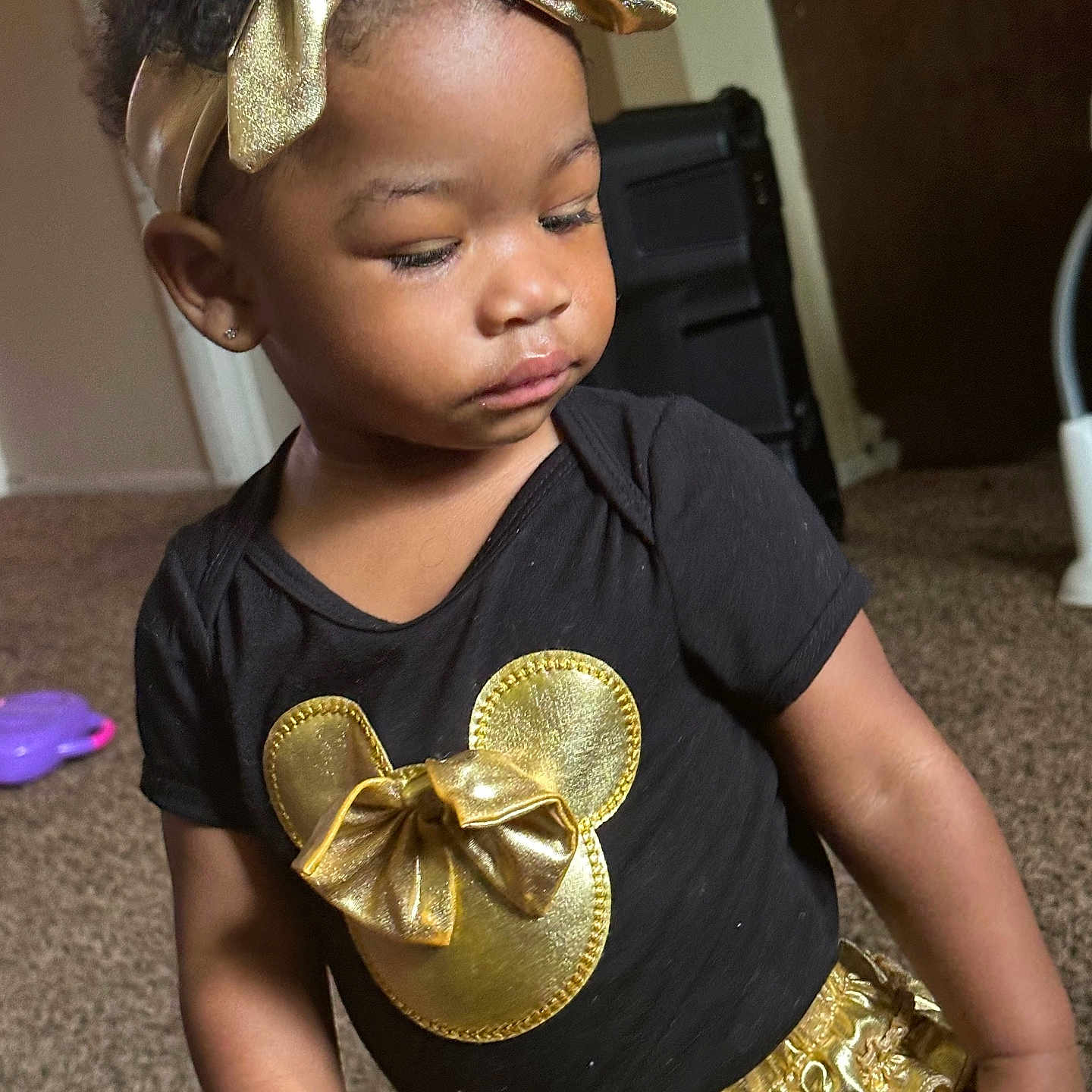 Saeyah joined the competition — help win amazing prizes! black_shirt, bow, carpet, child, clothing, curly_hair, cute, earrings, expression, fashion, gold, golden_skirt, headband, indoor, minnie_mouse, person, portrait, standing, toddler, young_child
