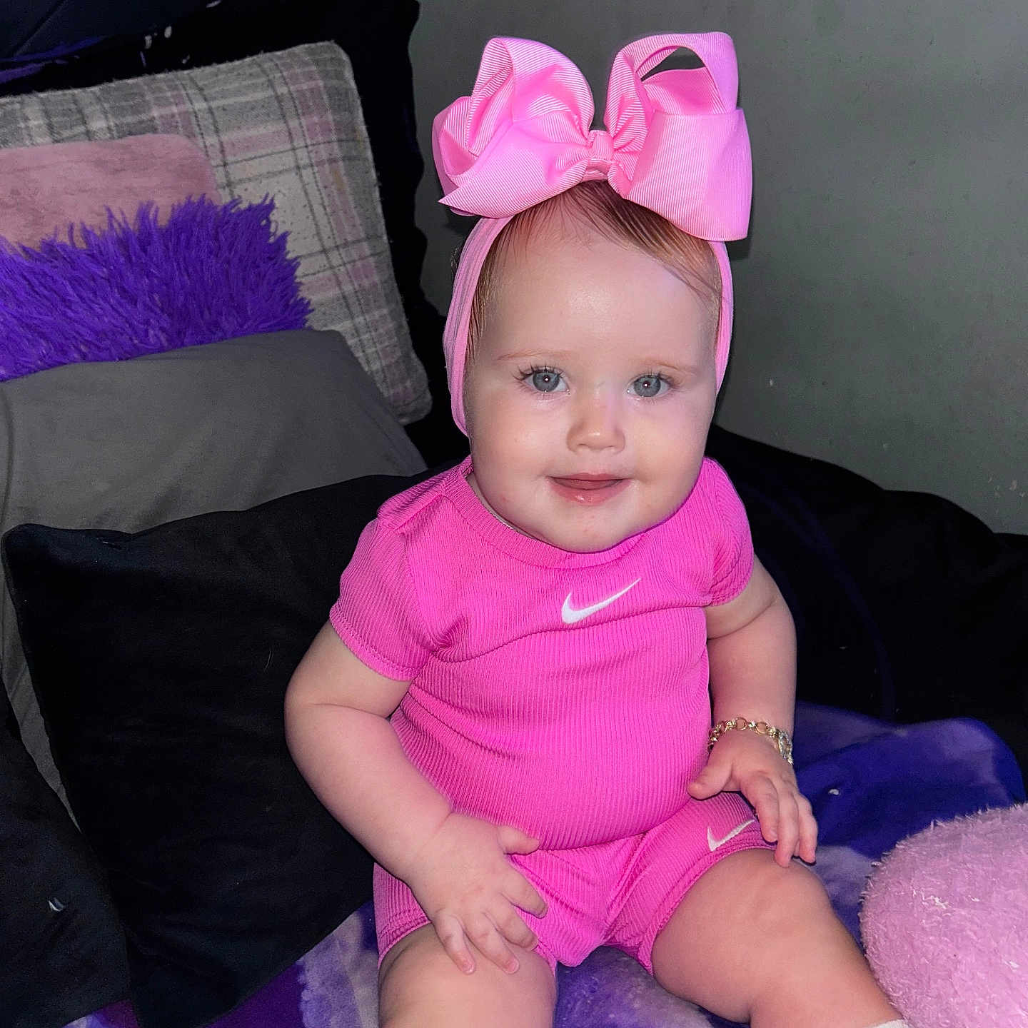 Frankie-Rae joined the competition — help win amazing prizes! apparel, baby, bow, bracelet, child, couch, cute, fashion, happy, headband, indoor, infant, person, pillow, pink_clothing, portrait, sitting, smiling, white_socks, young_child