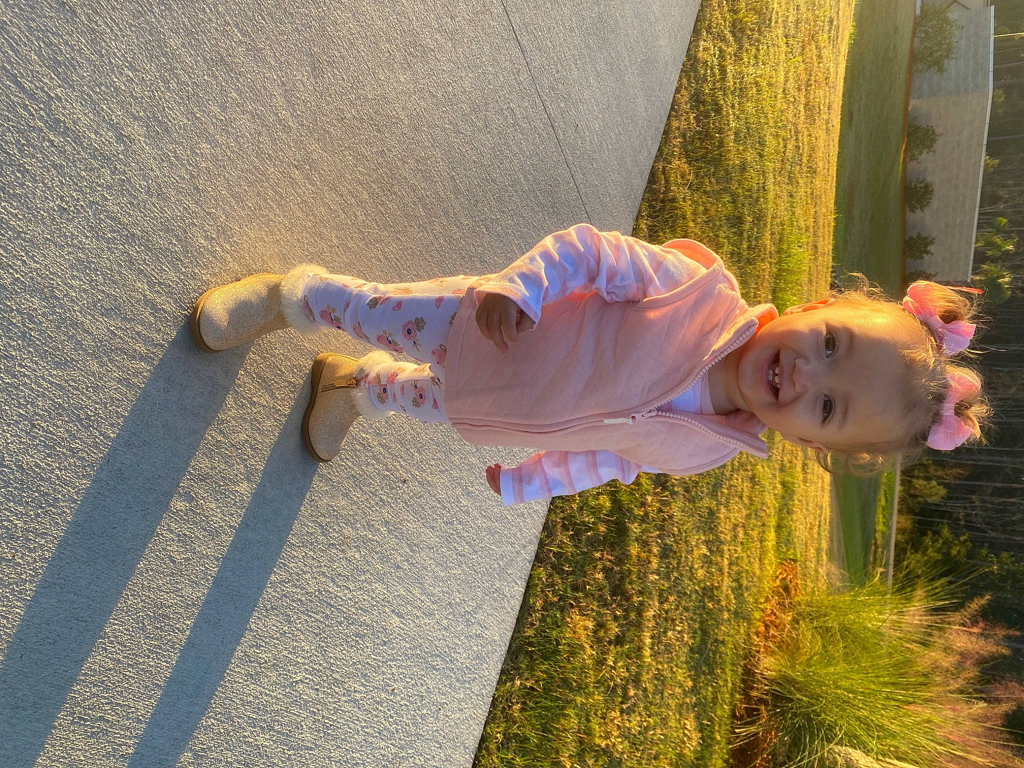 Cali is registered to the contest to win money with this photo: child, flooring, fun, grass, happy, human_leg, joy, leisure, people_in_nature, person, plant, road_surface, shadow, smile, tints_and_shades, toddler, tree, wood